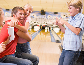 Familie hygger sig med at spille bowling sammen