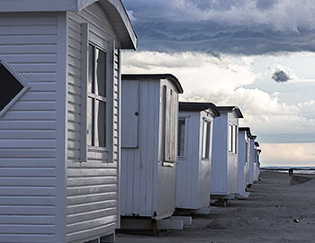 De hvide badehuse på række på stranden ved Blokhus