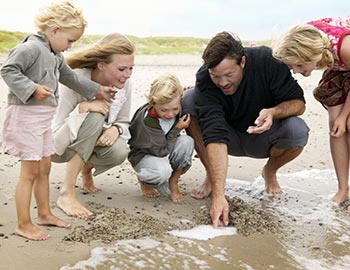 Forældre og børn i strandkanten